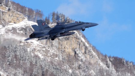 Photo for Meiringen Switzerland January 19 2023: Modern supersonic air defense jet lifts off against a spectacular snowy mountain panorama for security mission for World Economic Forum WEF in Davos. Copy Space - Royalty Free Image