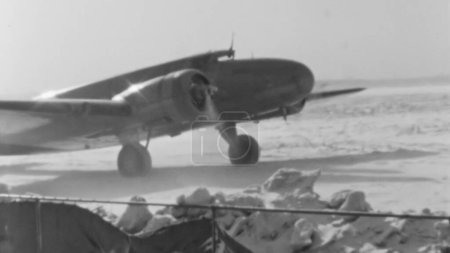Téléchargez les photos : Image évocatrice des années 1930 Avion de passagers arrêté sur piste enneigée à New York avec les moteurs allumés. Ciel nuageux et neige au sol par une journée ensoleillée d'hiver. Boeing 247 de United Air Lines - en image libre de droit