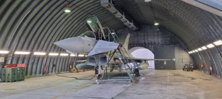 Téléchargez les photos : Istrana Italie 13 décembre 2023 : Un Eurofighter Typhon moderne de l'OTAN, armé et stationné dans un hangar, se prépare au décollage immédiat sur alarme. Idéal pour un usage rédactionnel, avec espace de copie. - en image libre de droit