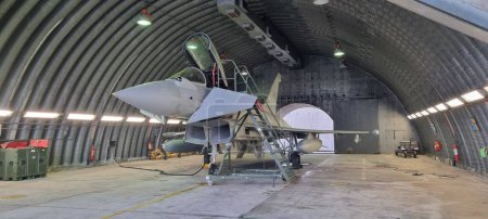 Téléchargez les photos : Istrana Italie 13 décembre 2023 : Un Eurofighter Typhon moderne de l'OTAN, armé et stationné dans un hangar, se prépare au décollage immédiat sur alarme. Idéal pour un usage rédactionnel, avec espace de copie. - en image libre de droit