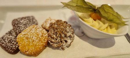 Téléchargez les photos : Délicieux choix de biscuits saupoudrés de sucre en poudre, servis avec un côté de crème fouettée - en image libre de droit