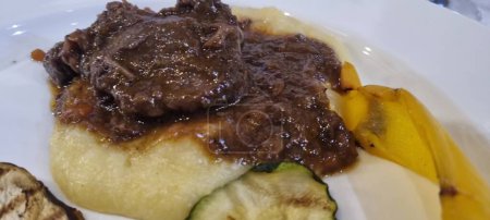 Delicious beef steak in rich gravy served with creamy polenta and fresh grilled vegetables