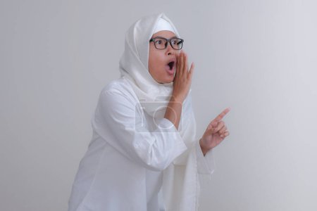 Téléchargez les photos : Asiatique fille en musulman vêtements debout et bavardage - en image libre de droit