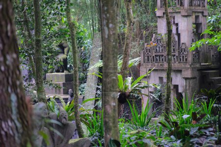 Foto de Lugar de aspecto sagrado con edificio antiguo y estatuas cubiertas de musgo en la selva tropical - Imagen libre de derechos