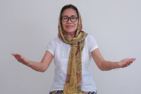 Foto de Retrato de una mujer musulmana asiática de mediana edad con los brazos abiertos en las vacaciones del Ramadán - Imagen libre de derechos