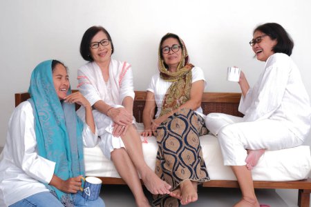 Foto de Tres mujeres sentadas con su madre que les cuenta su experiencia y les aconseja - Imagen libre de derechos