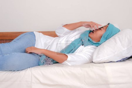 Téléchargez les photos : Asiatique fille tombé endormi dans l 'canapé avec son smartphone tombé sur son visage - en image libre de droit