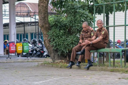Photo for Two government officials taking a break at lunch time outside the office in Yogyakarta 20 February 2023 - Royalty Free Image