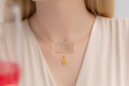 Elegant silver necklace around the neck of a well-groomed lady in a cream blouse. Photos for e-commerce, social media, product sales.