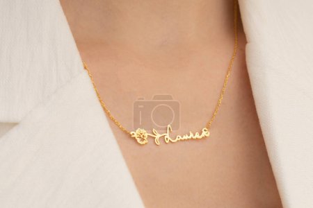 Portrait of elegant woman wearing jewelry: personalized silver necklace. Woman in white outfit with soft color make-up.