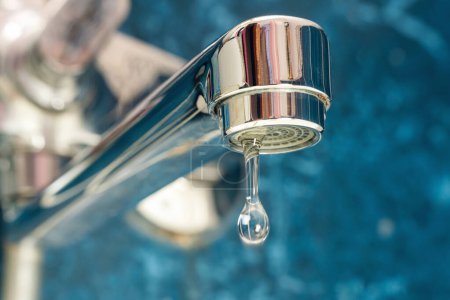 Téléchargez les photos : A drop of water drips from a leaky faucet. - en image libre de droit