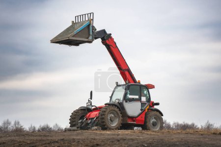 Wheel loader with telescopic mast, construction machinery for lifting and moving goods.