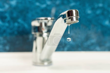Téléchargez les photos : A drop of water drips from a leaky faucet. - en image libre de droit