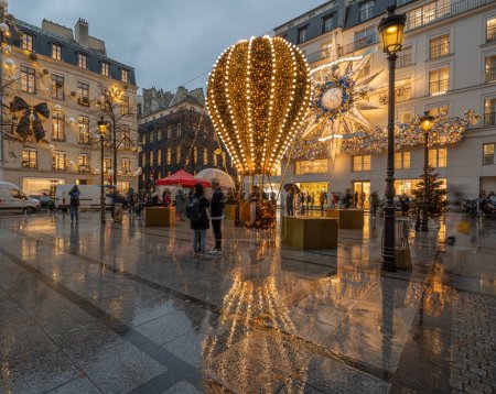 Foto de Vista de las fachadas de Christian Dior Paris y Coco Chanel con decoración navideña en una noche lluviosa - Imagen libre de derechos