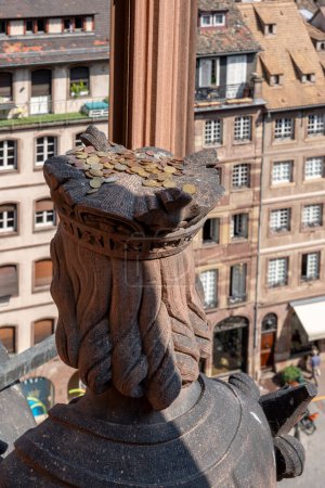 Photo for Strasbourg, France - 06 26 2023: Strasbourg cathedral: View of a statue with coins on the head on the roof of the cathedral and the city behind - Royalty Free Image