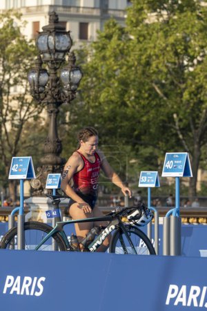 Foto de París, Francia - 08 17 2023: prueba de triatlón París 2024. Mujeres triatletas al inicio de la carrera ciclista justo después de la carrera de natación en el puente Alexandre II - Imagen libre de derechos