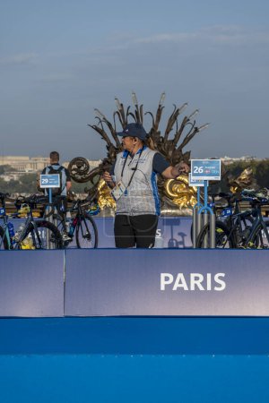 Photo for Paris, France - 08 17 2023: Paris 2024 triathlon test event. The technical manager controlling the bicycle area on Alexandre III bridge - Royalty Free Image