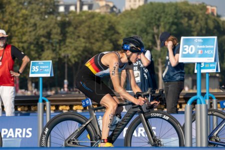 Photo for Paris, France - 08 17 2023: Paris 2024 triathlon test event. Women triathletes at the cycling race on the Alexandre II bridge - Royalty Free Image