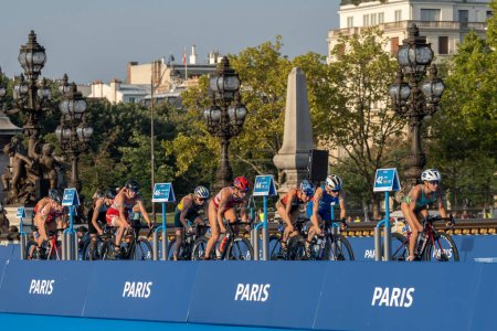 Foto de París, Francia - 08 17 2023: prueba de triatlón París 2024. Mujeres triatletas en la carrera ciclista en el puente Alexandre II - Imagen libre de derechos