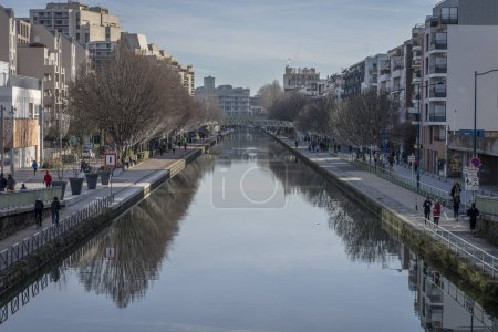 Téléchargez les photos : Paris, France - 01 27 2024 : Canal d'Ourcq. Réflexions sur le canal de l'Ourcq de bâtiments et d'arbres - en image libre de droit