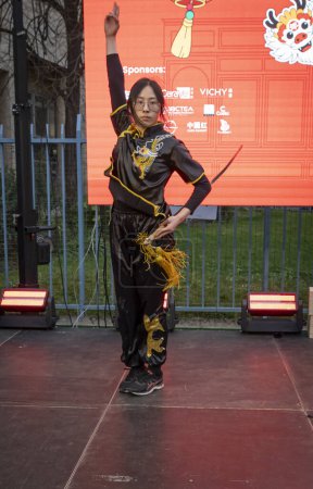 Photo for Paris, France - 02 03 2024: Chinese New Year. Woman swordsmanship demonstration during festivities for the Year of the Dragon in the Belleville district - Royalty Free Image