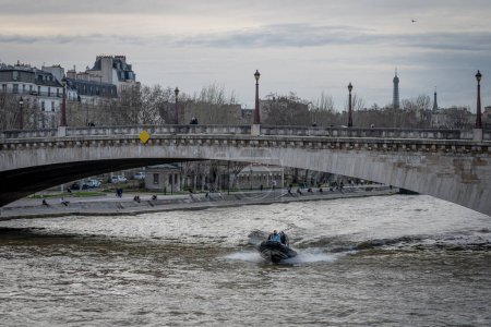 Photo for Paris, France - 02 15 2024: View of water policemen sailing on La Seine with a semi-rigid boat - Royalty Free Image