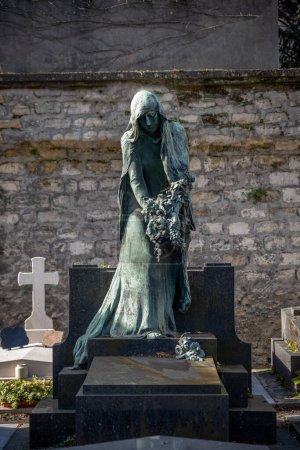 Foto de París, Francia - 02 17 2024: Cementerio de Montmartre. Vista de una escultura y las tumbas alrededor - Imagen libre de derechos