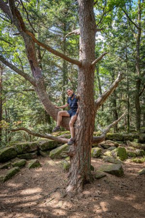 Mont Sainte Odile, Francia - 09 11 2020: El camino de los galos. Vista de una mujer excursionista trepando a un árbol
