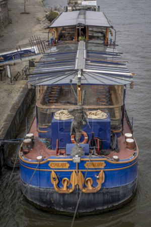Paryż, Francja - 03 08 2024: Wybrzeże Sekwany. Widok na czerwono-niebieską drewnianą barkę zacumowaną na nabrzeżu