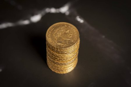 Stillleben. Stapel goldener Louis-Münzen in Großaufnahme auf einer schwarz-weißen Marmoroberfläche