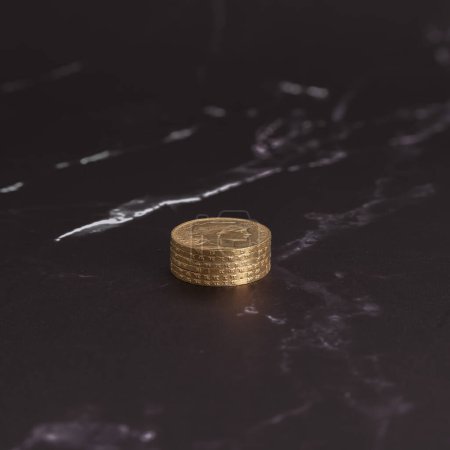 Stillleben. Stapel goldener Louis-Münzen in Großaufnahme auf einer schwarz-weißen Marmoroberfläche