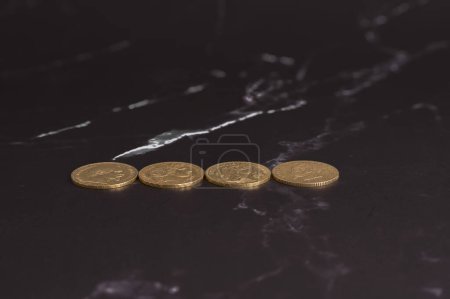 Paris, France - 03 26 2024: Still life. Close-up view stack of golden Louis coins on a black and white marble surface
