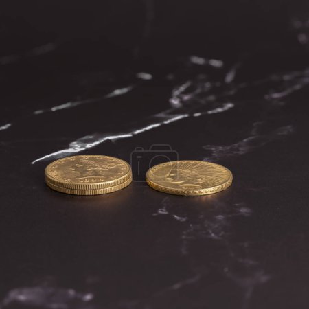 París, Francia - 03 26 2024: Bodegón. Vista de cerca pilas de monedas de oro americano en una superficie de mármol blanco y negro