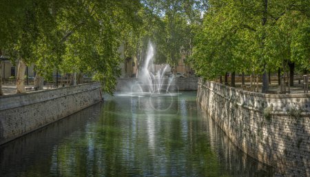 Nimes, Francia - 04 17 2024: The Gardens of The Fountain. Vista de chorros de agua desde el muelle de la fuente