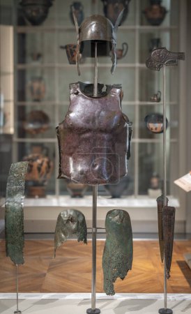 Paris, France - 05 10 2024: Sport in Antiquity. View of an armor of an Italic warrior, winged helmet, Attic anatomical breastplate, cnemides, belt