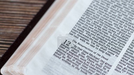 Resurrection of dead prophecy, biblical verse in open Holy Bible Book placed on wooden background. A close-up. Christian biblical concept of hope, eternal life, second coming of God Jesus Christ.
