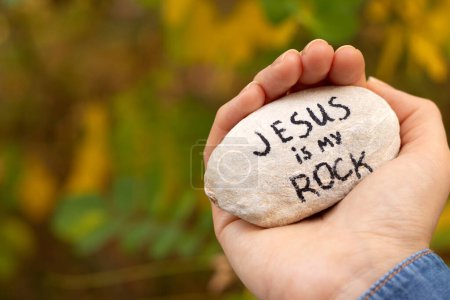 Téléchargez les photos : Main tenant une pierre avec l'écriture "Jésus est mon rocher" dans la nature. Ferme là. Texte chrétien inspirant verset, fondement solide, force et espérance en Dieu. Concept biblique. - en image libre de droit