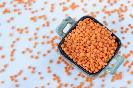 Red lentils in a bowl isolated on white background. Top view. Healthy organic legume food concept.