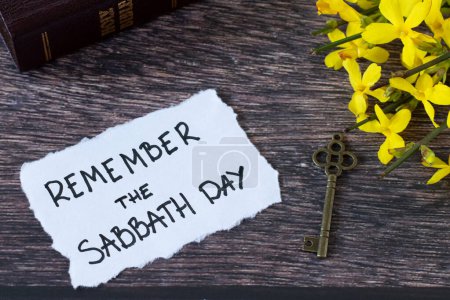 Erinnern Sie sich an den Sabbattag, handgeschriebene Notiz mit heiliger Bibel und altem Schlüssel auf Holz. Christlicher Gehorsam, die Einhaltung der Gebote, Ruhe für das Volk Gottes, biblisches Konzept.