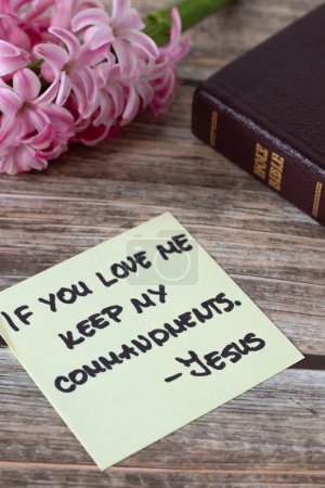 Si vous M'aimez gardez Mes commandements, Jésus-Christ, citation manuscrite avec le livre saint de bible et fleur sur le bois. Gros plan. L'obéissance chrétienne à Dieu, 10 commandements, concept biblique.