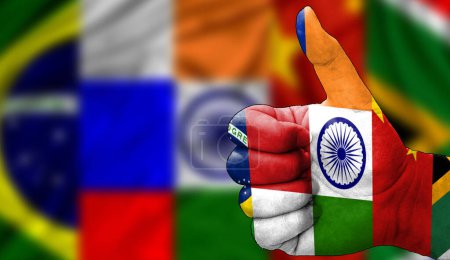 Hand mit Daumen nach oben in Anerkennung der BRICS-Flagge aufgemalt. Bild mit Flaggen-Hintergrundbereich unscharf, Kopierbereich. Union Brasilien Russland Indien China Südafrika Fahnen