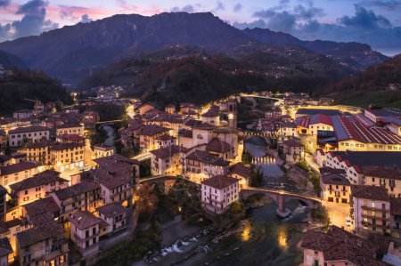 Foto de Hermoso paisaje urbano de noche aérea de la pequeña ciudad de Bérgamo a la hora azul, San Giovanni Bianco, Bérgamo, Val Brembana, Lombardía, Italia. - Imagen libre de derechos