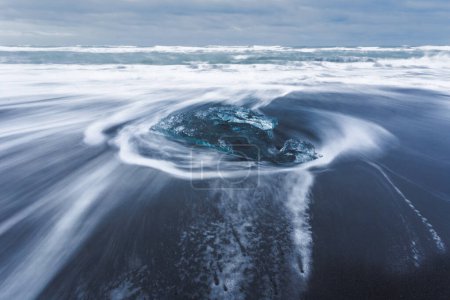 Téléchargez les photos : Rocher de glace avec plage de sable noir à la plage de Jokulsarlon, Plage de diamant, dans le sud-est de l'Islande. - en image libre de droit