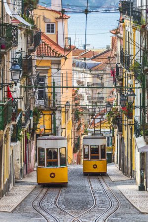 Traditional yellow trams, funicular on a street in Barrio Alto, Lisbon, Portugal.