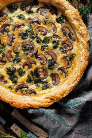 Photo for Close-up view of the mushroom quiche with addition of parsley, top view. Delicious vegetarian food - Royalty Free Image