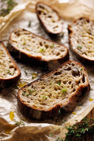 Photo for Grilled slices of sourdough bread with olive oil and thyme, close-up - Royalty Free Image