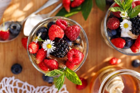 Photo for Healthy dessert or breakfast made of natural greek yoghurt, honey, fresh blueberries, raspberries and strawberries, top view - Royalty Free Image