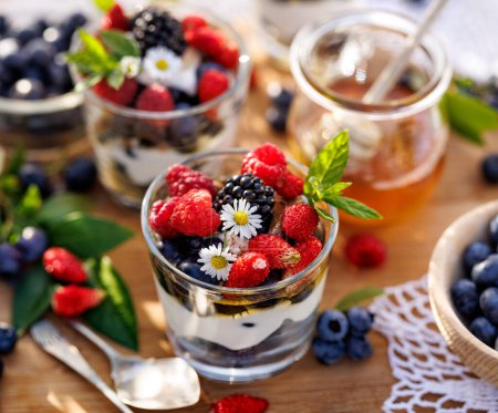 Photo for Healthy dessert or breakfast made of natural greek yoghurt, honey, fresh blueberries, raspberries and strawberries, close up view - Royalty Free Image