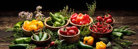 Photo for Set of various colorful peppers and fresh herbs on a wooden table - Royalty Free Image