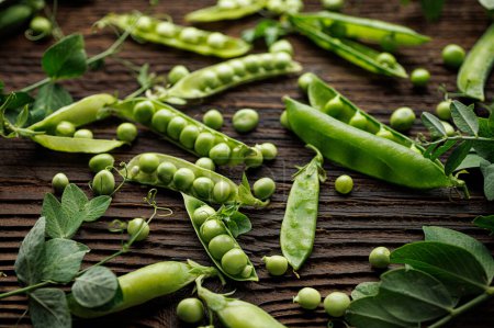 Photo for Green peas in split pods on a wooden background, close up view - Royalty Free Image